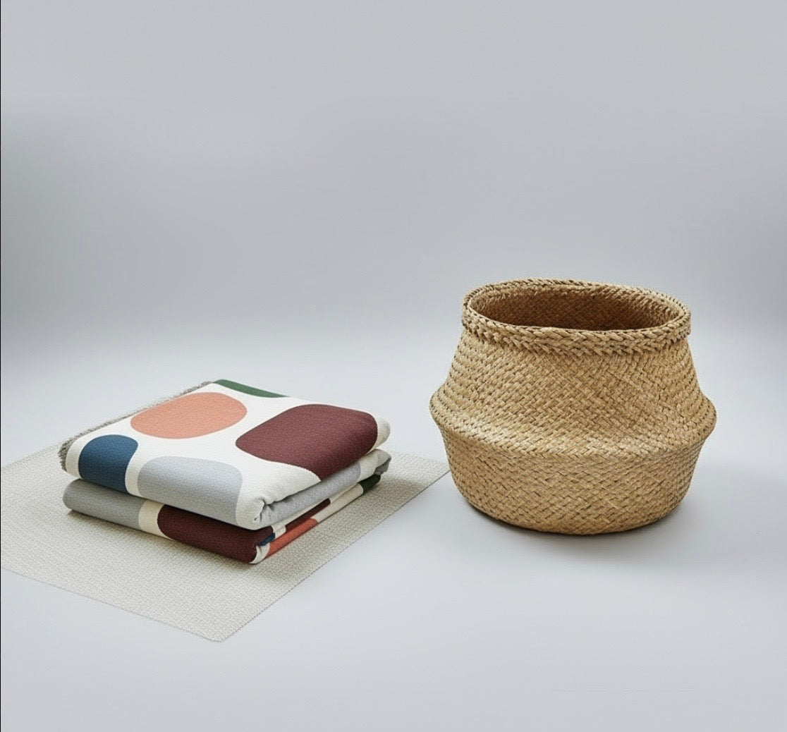 Woven basket next to folded throw on a light gray background