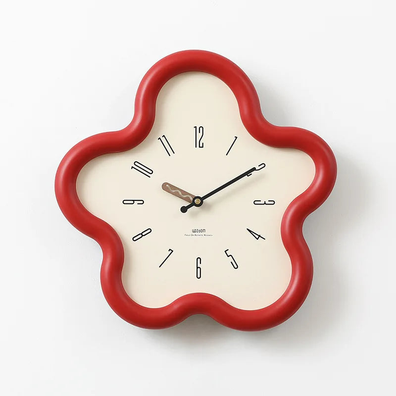 Decorative wall clock with a red frame on a gray surface against a white wall.