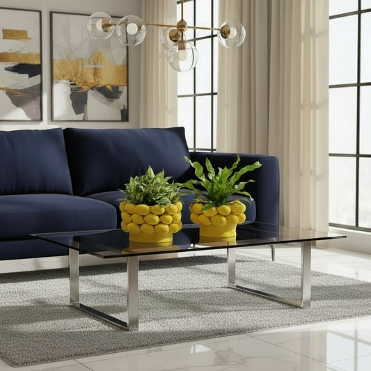 Two yellow lemon-shaped planters with green plants on a windowsill.