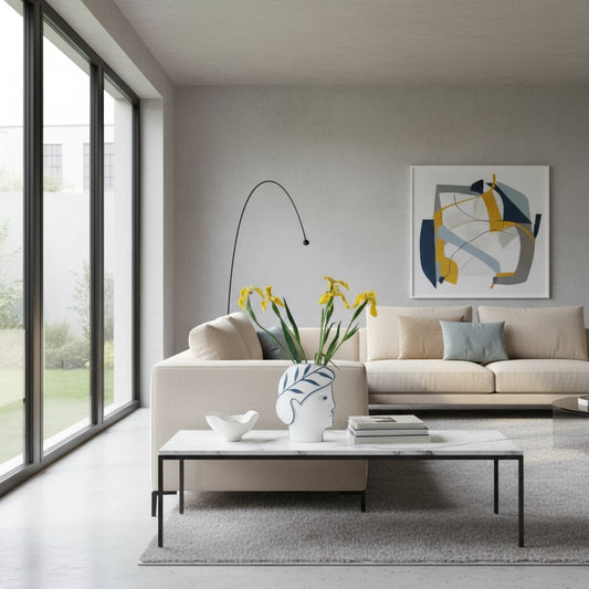 Decorative vase with face design on a table with flowers and candles.