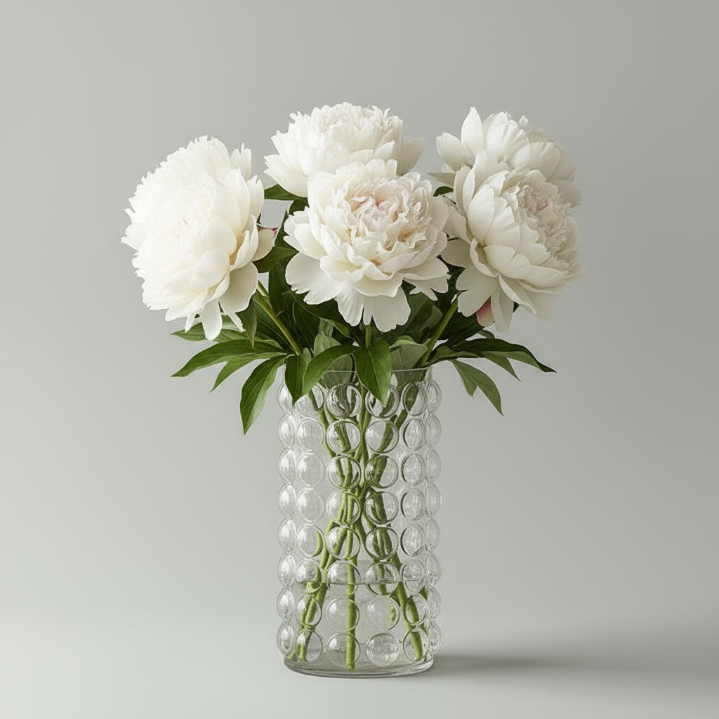 Clear glass vase with pink roses on a white background