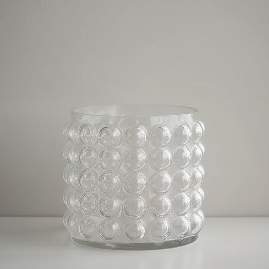 Clear glass vase with bubble design on a pink background