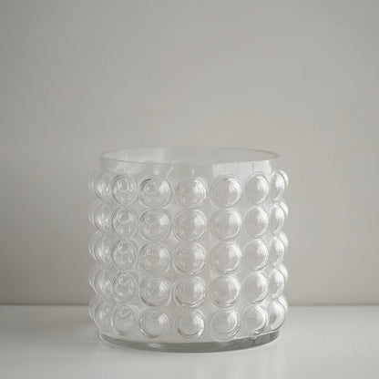 Clear glass vase with bubble design on a pink background