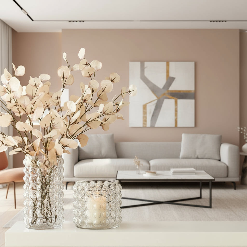 Decorative vase with white floral branches and a matching candle holder on a pink background