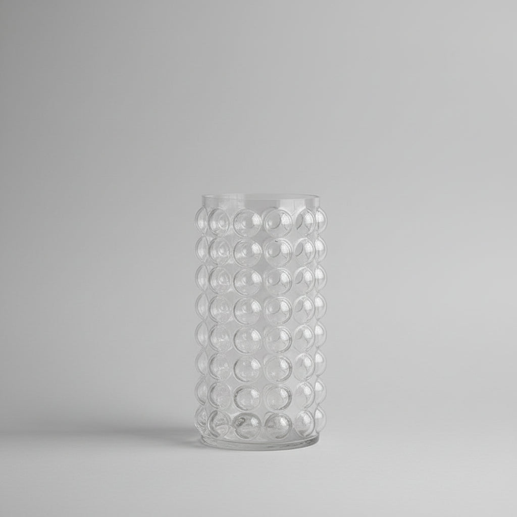 Clear glass vase with bubble design on a pink background