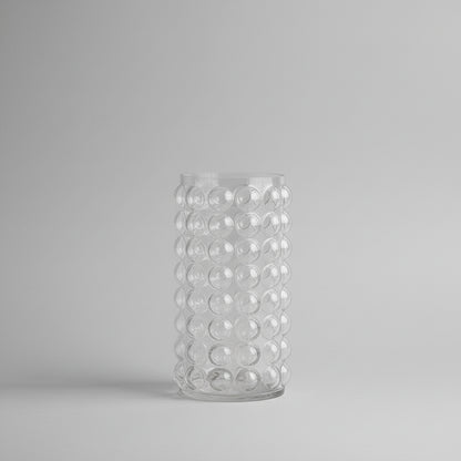 Clear glass vase with bubble design on a pink background