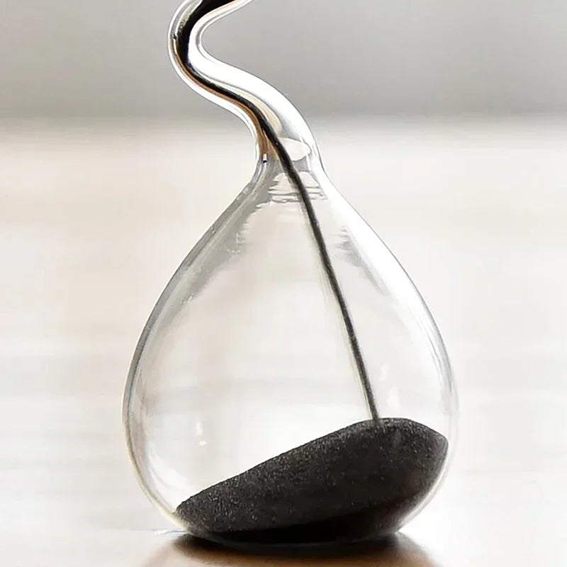 Glass hourglass with sand running through on a neutral background