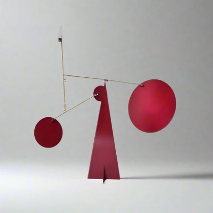 Red abstract sculpture with geometric shapes on a white background