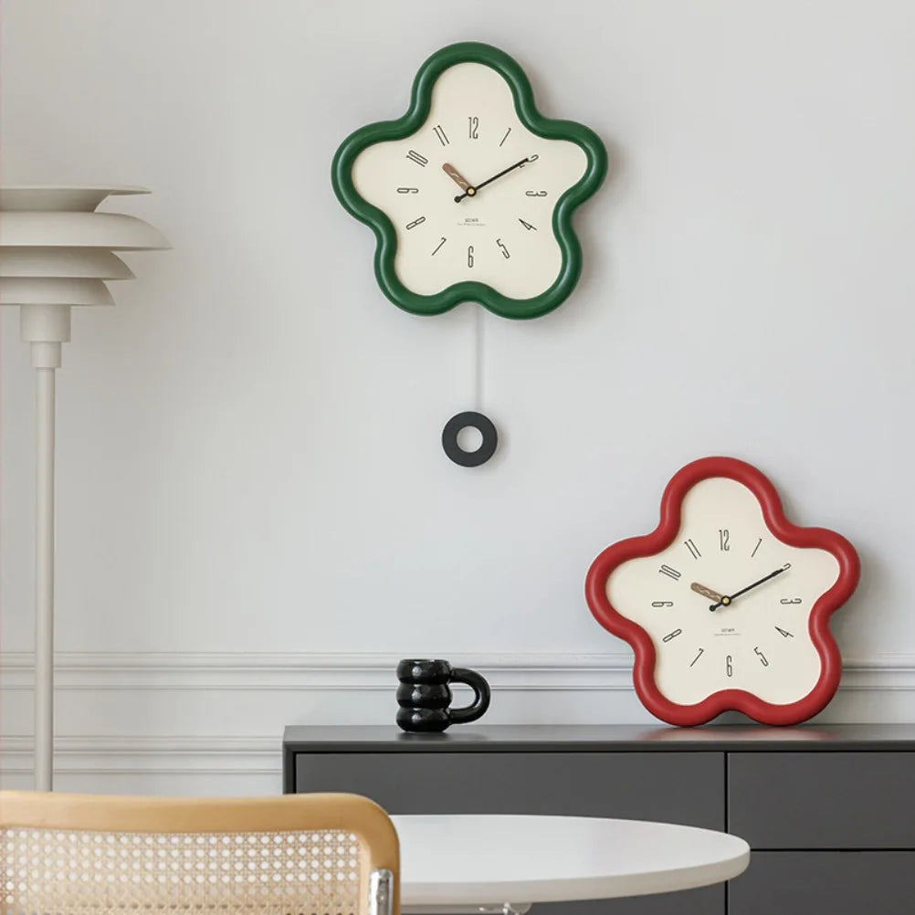 Two decorative wall clocks with green and red frames on a light gray wall.