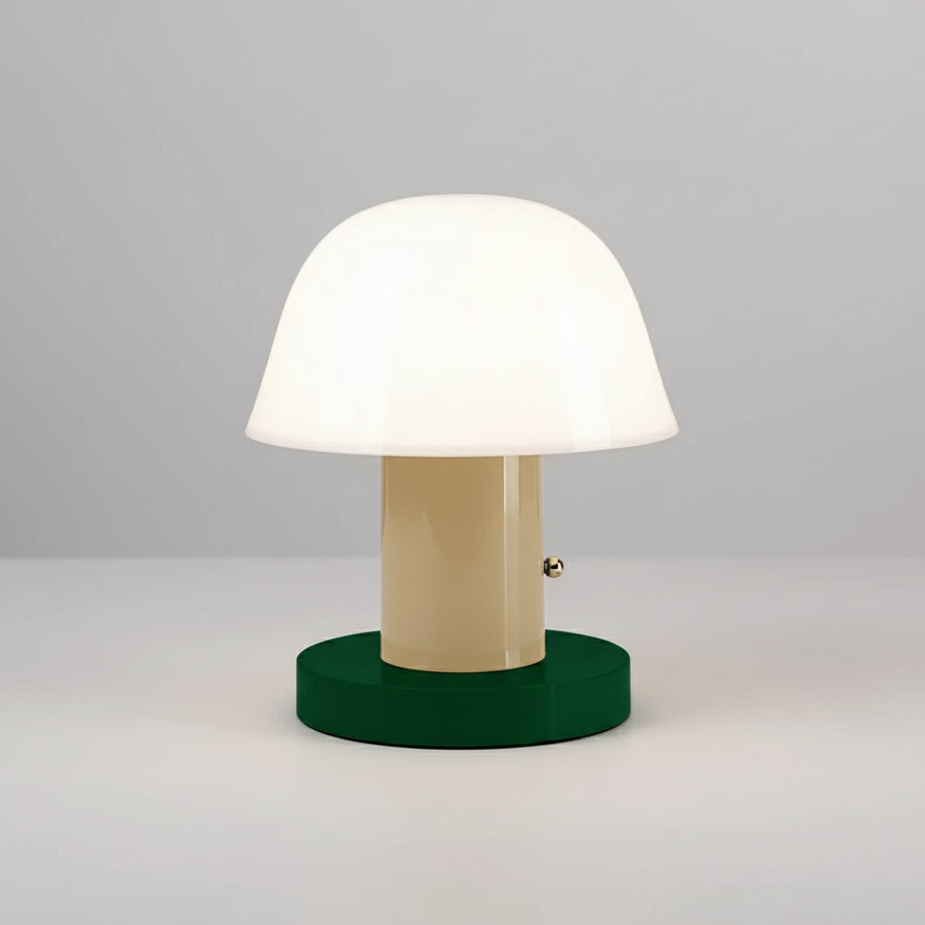 Table lamp with a green base and beige middle section on top of books