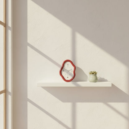 Decorative wall clock with a red frame on a white surface