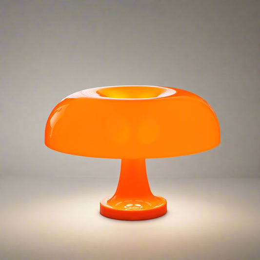 Orange table lamp on a reflective surface with a blurred background