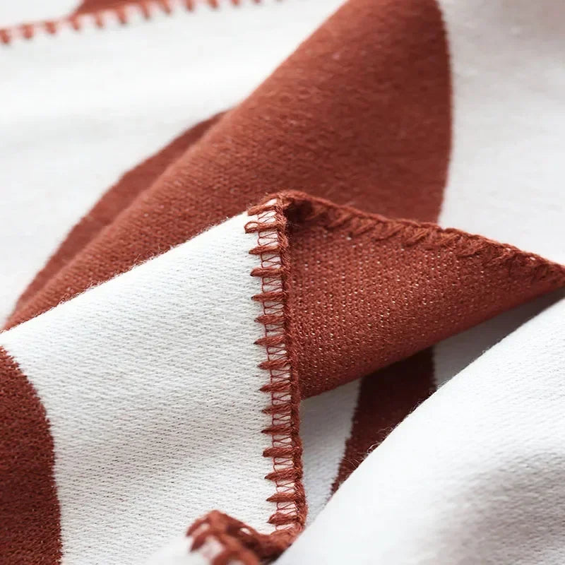 Close-up of a red and white striped throw with a zigzag edge.