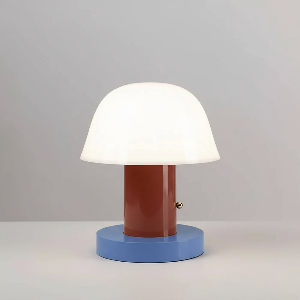 Table lamp with a white shade, brown cylindrical middle section, and blue base on top of books.
