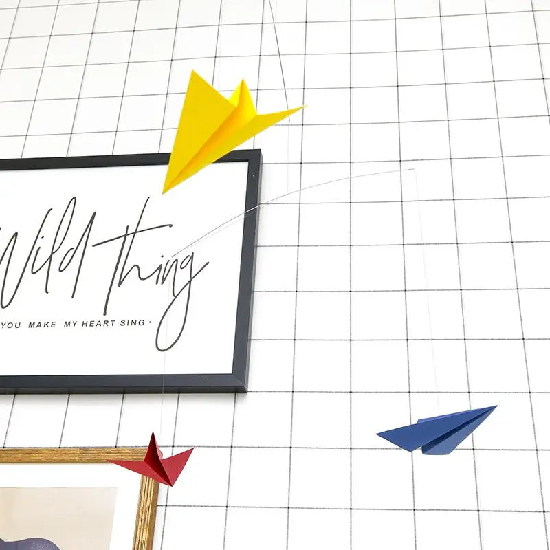 Colorful paper airplanes on a grid background