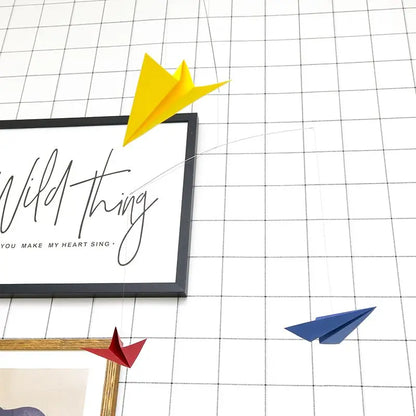 Colorful paper airplanes on a grid background