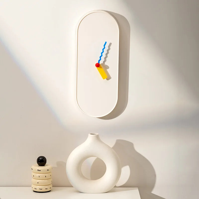 Modern wall clock with colorful design on a white wall