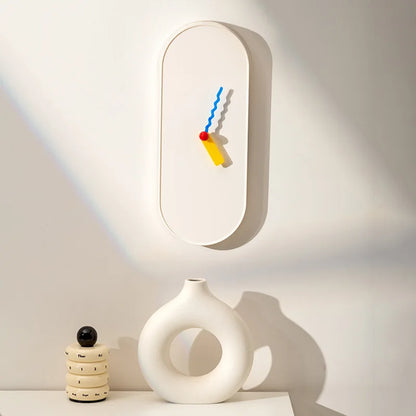 Modern wall clock with colorful design on a white wall
