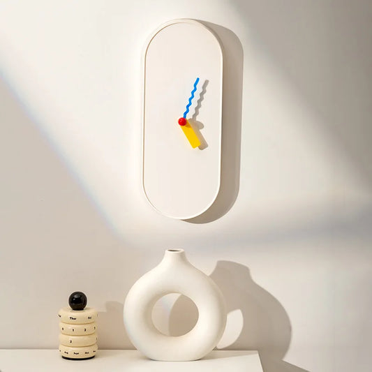 Modern wall clock with colorful design on a white wall