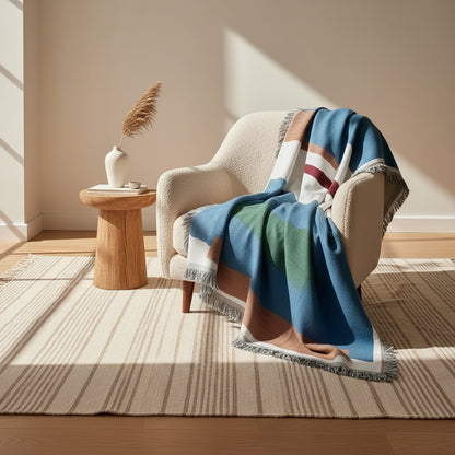 Colorful striped blanket draped over a sofa in a living room.