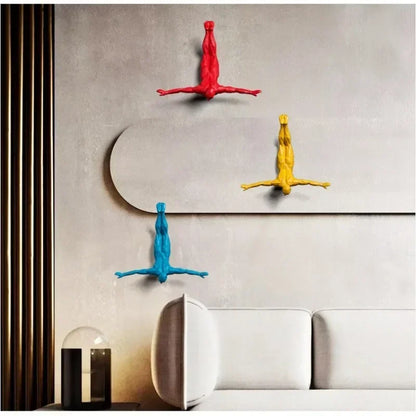 Colorful wall hooks shaped like people on a neutral wall with a modern interior setting.