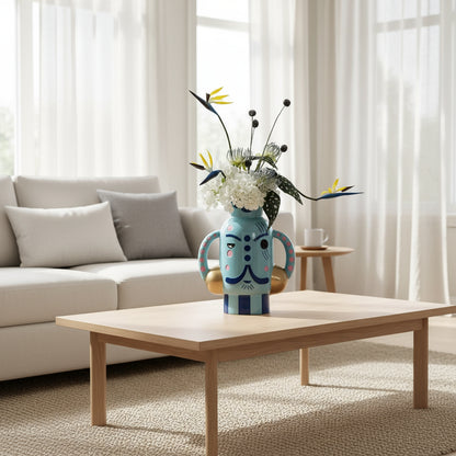 Decorative vase with a face design, flowers, on a modern living room