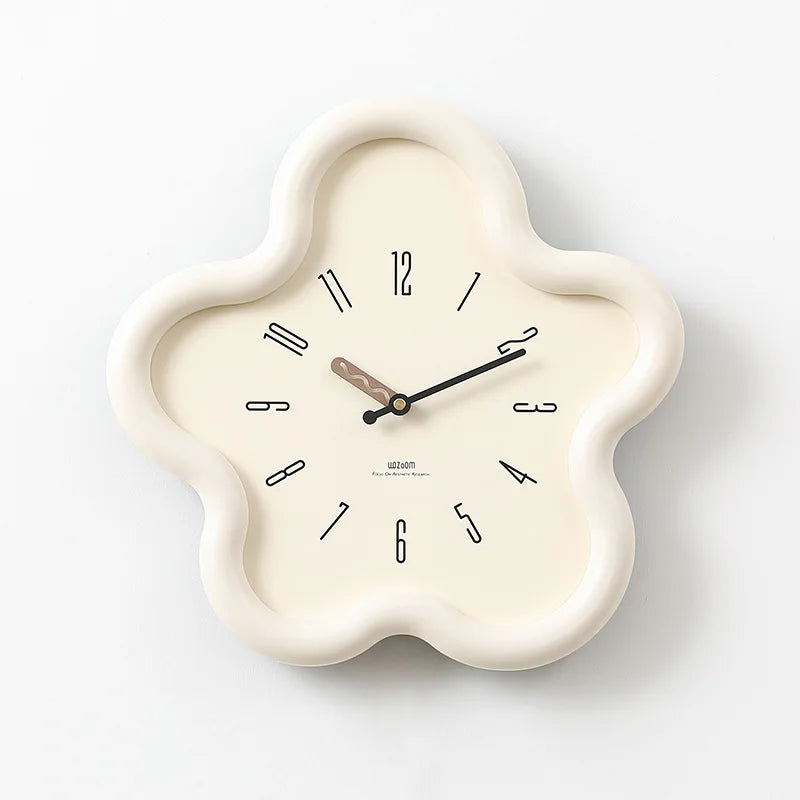 Decorative wall clock with a white frame on a gray surface against a white wall.