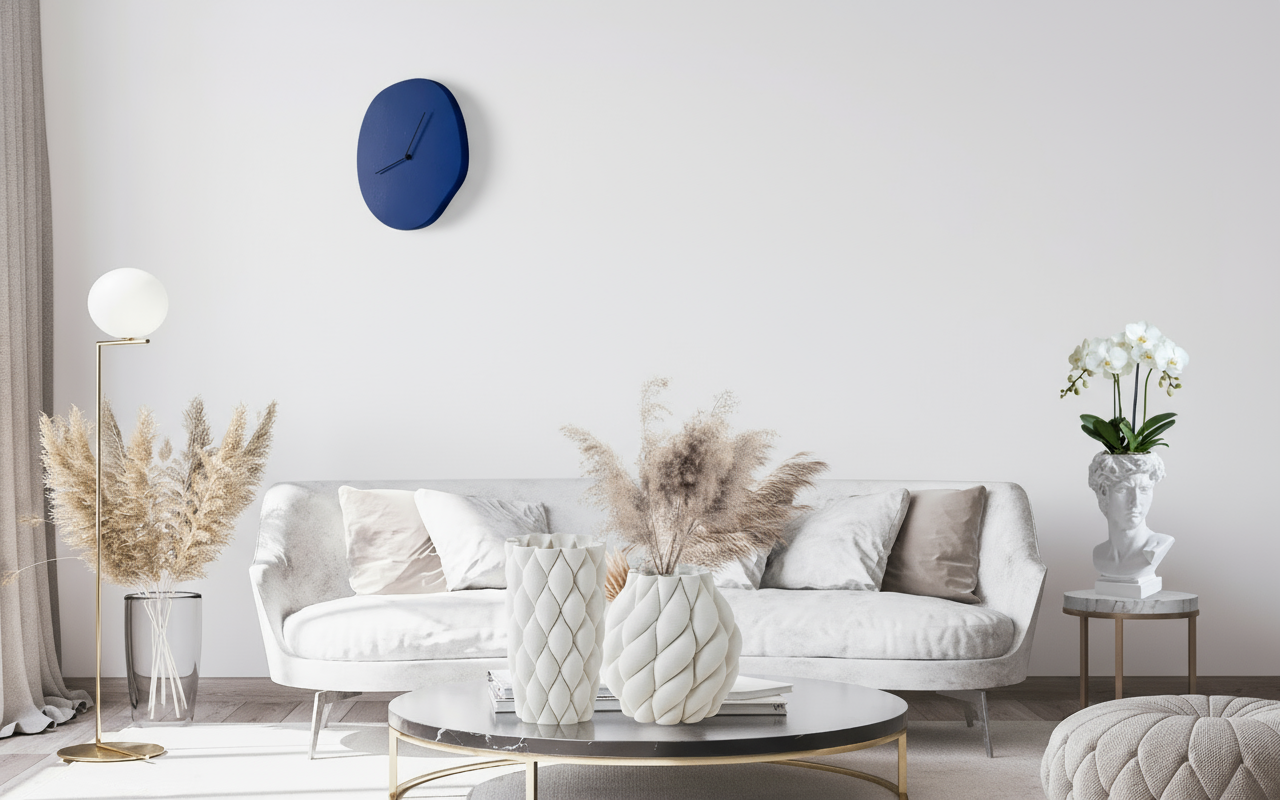 Modern living room with white sofa, decorative pillows, and a blue wall clock.