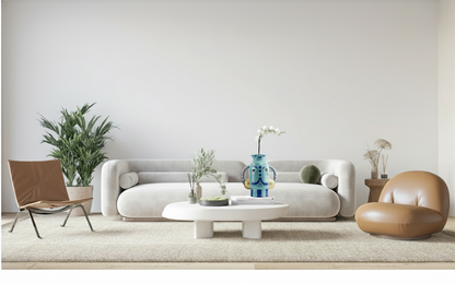 Modern living room with a white sofa, brown chair, and decorative items.
