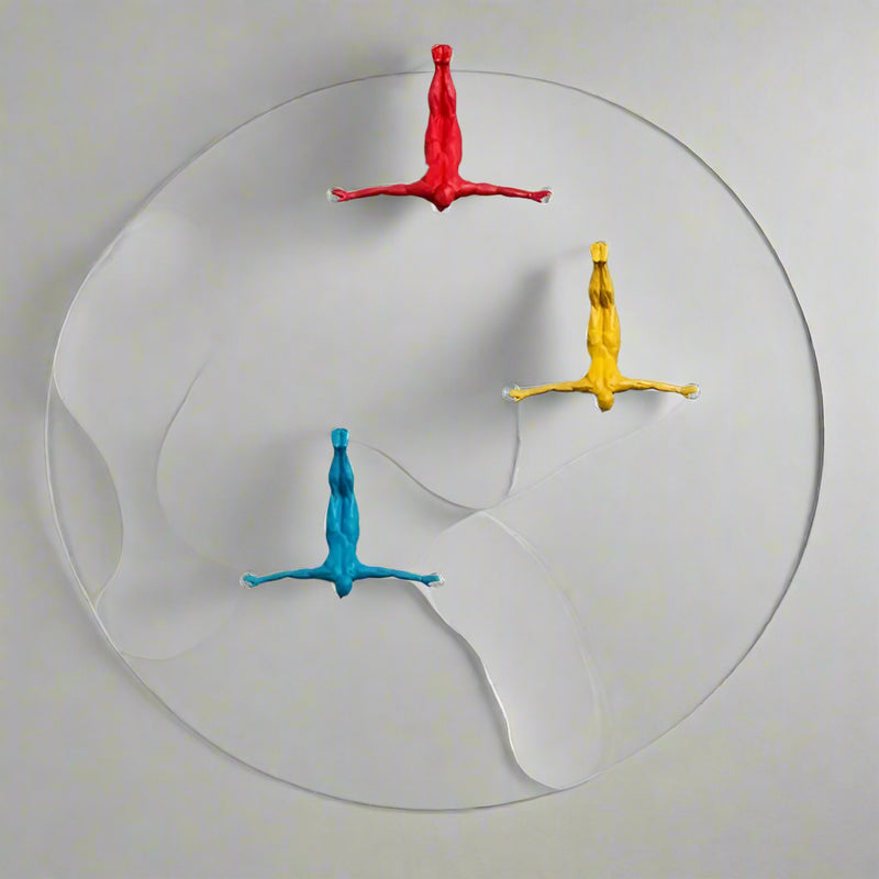 Colorful wall hooks shaped like people on a neutral wall with a modern interior setting.